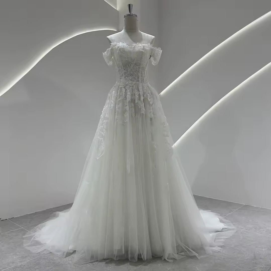wedding dress with sequin underlay Ethereal details with a touch of modern charm Style 20063 is classic A-line gown with a beautiful illusion bodice and organza 3-D floral details that cascade down a shimmering galaxy tulle