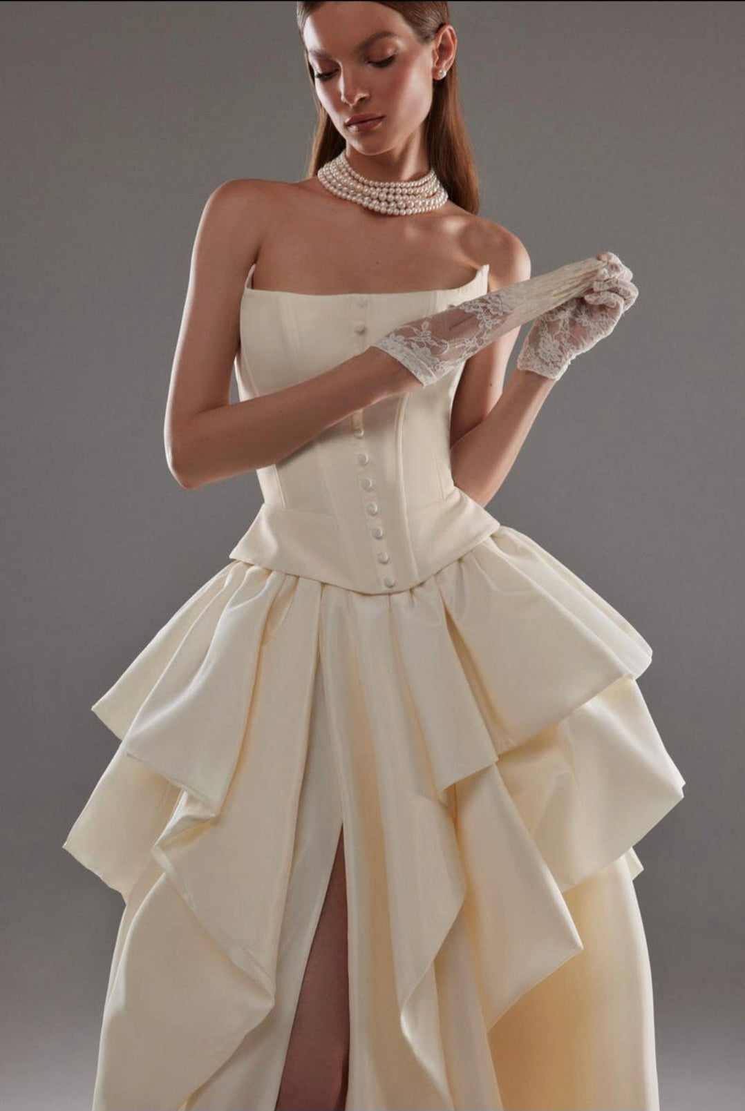 Cat Eye Boat Neck Strapless Front Multi Button Detail Corset Bridal And Ceremonial Gown With Multi Layered Skirt And Split Hem