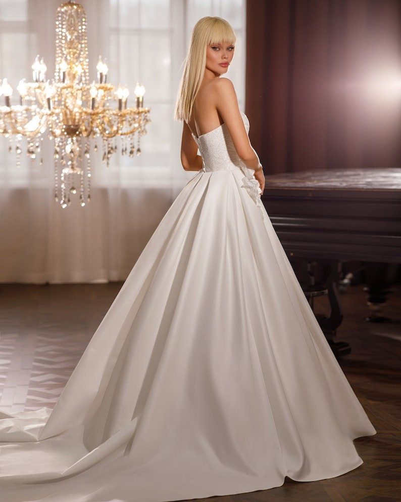 Beautiful Strapless Shimmering Scoop Neck Underlay With Pleated Satin Overlay And Shimmering 3D Flower Waistline Detail A-Line Gown