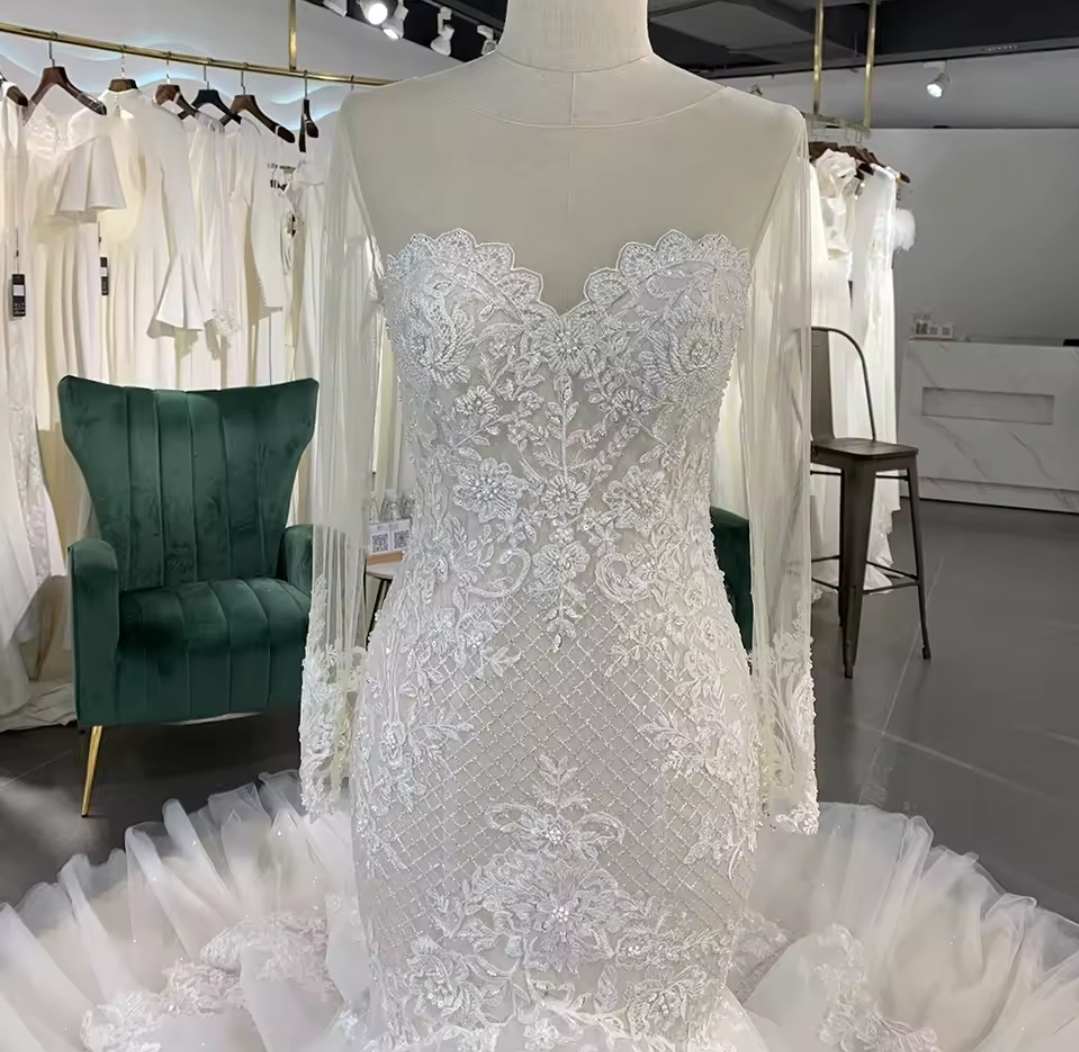 Long Sleeve Illusion Sleeve And Neckline Lace Sweetheart Fit To Flare Bridal Gown With Multi Layered Tiered Skirt Hem And Button Up Enclosure