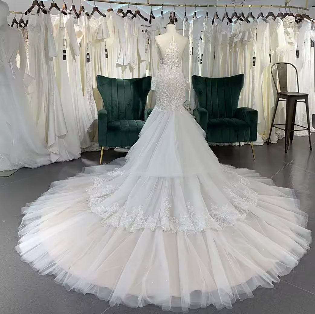 Long Sleeve Illusion Sleeve And Neckline Lace Sweetheart Fit To Flare Bridal Gown With Multi Layered Tiered Skirt Hem And Button Up Enclosure