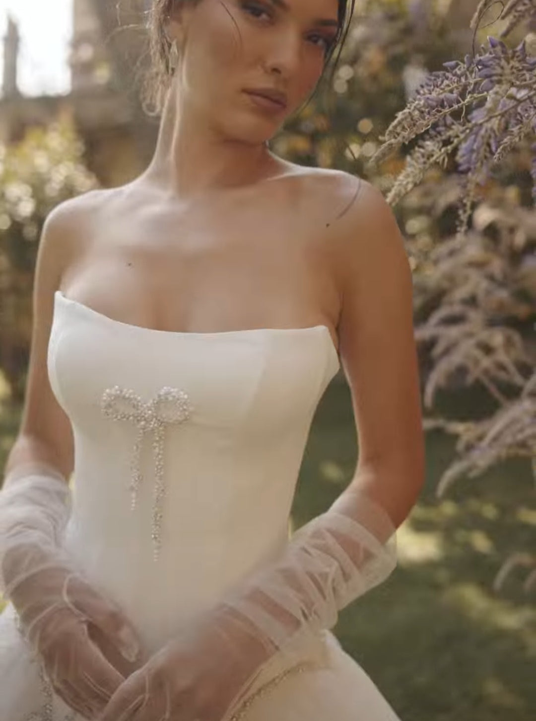 Cat Eye Scoop Strapless Corset With Center Beaded Bow Embellishment Bodice Wedding Gown With Multi Beaded Bow Scalloped Waist Detail And Detached Sheer Tulle Gloves