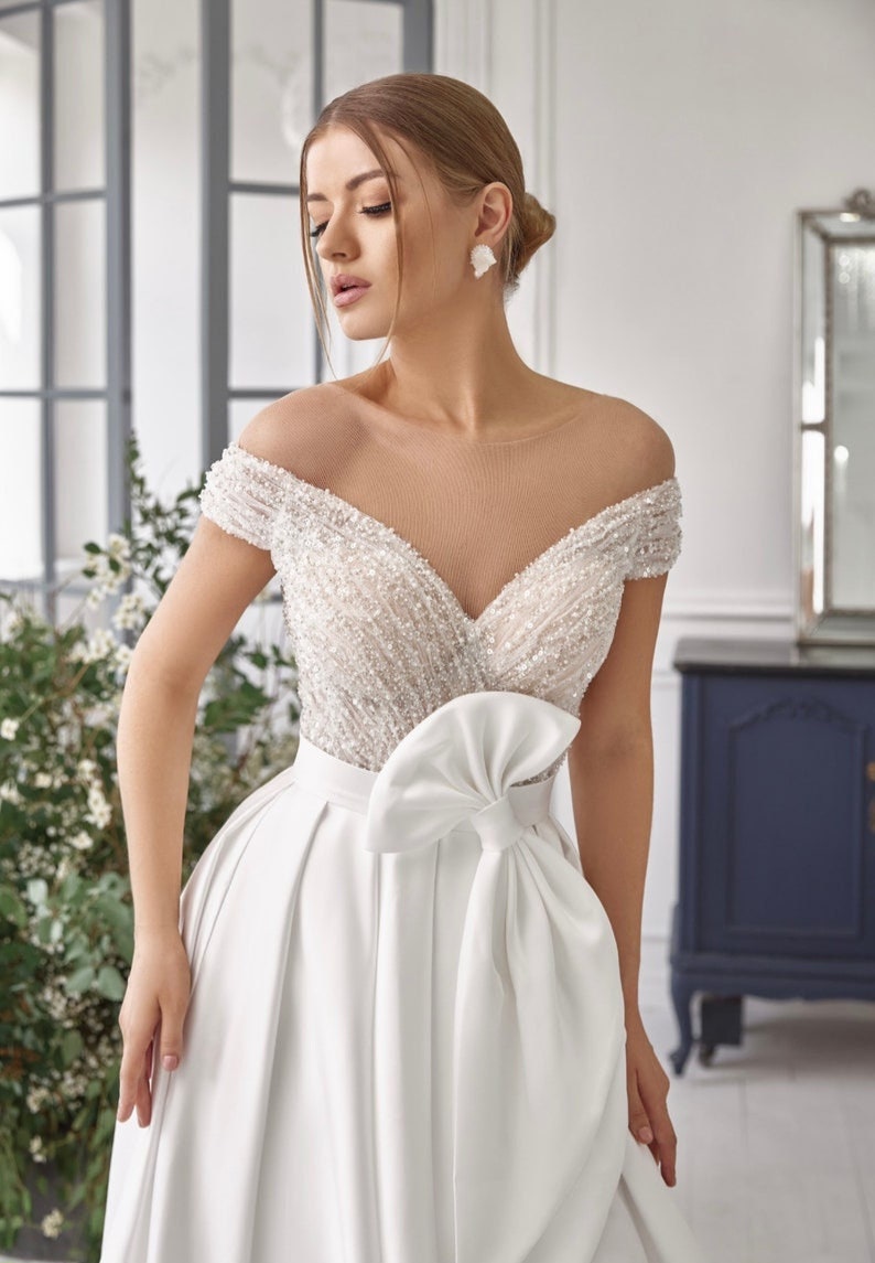 Off The Shoulder Open Back Illusion V Neck Sequinned Bodice Pleated Split Hem Gown With Bow Knot Waistline Detail